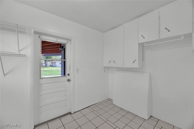 clothes washing area with light tile patterned floors