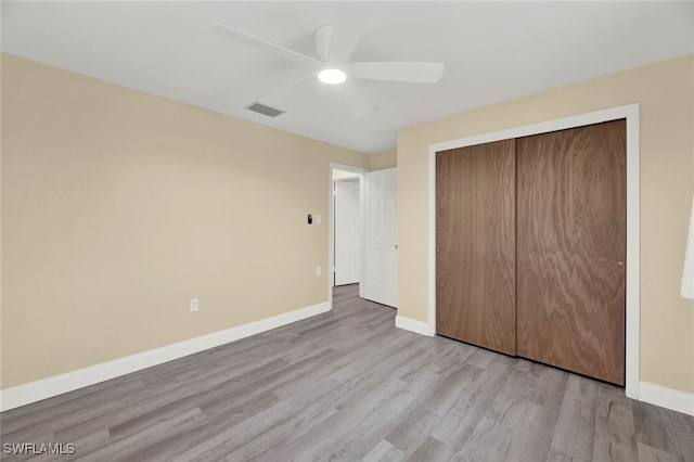 unfurnished bedroom featuring light hardwood / wood-style floors, ceiling fan, and a closet