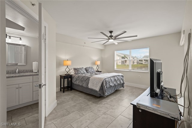 bedroom with sink, light tile patterned floors, ceiling fan, and ensuite bath