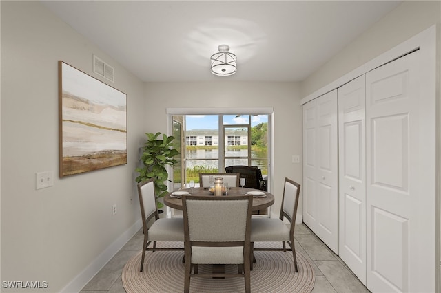 tiled dining space featuring a water view