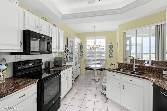 kitchen with tasteful backsplash, a tray ceiling, a sink, and black appliances