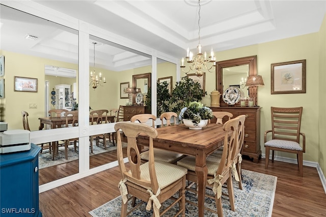 dining room with hardwood / wood-style floors, a raised ceiling, and an inviting chandelier