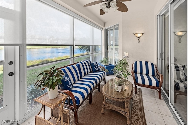 sunroom featuring a water view and ceiling fan