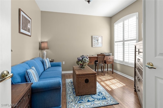 living area with baseboards and wood finished floors