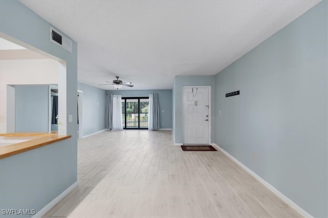 unfurnished living room with ceiling fan and light wood-type flooring