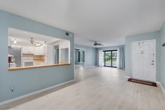 unfurnished living room featuring light hardwood / wood-style flooring and ceiling fan