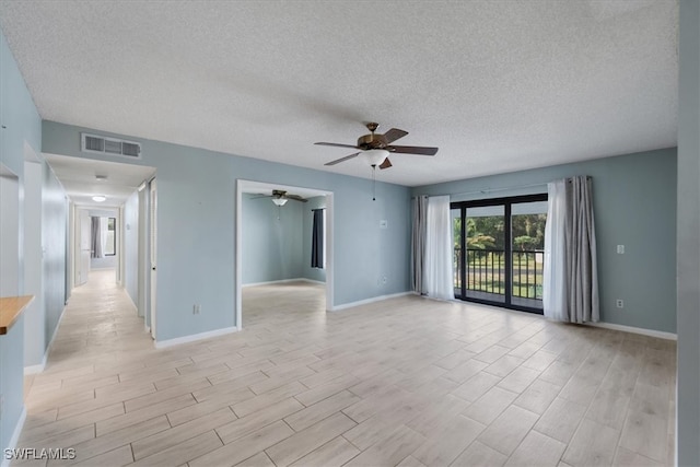 unfurnished room with a textured ceiling, ceiling fan, and light hardwood / wood-style flooring