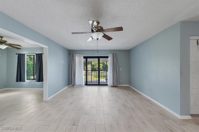 unfurnished room with light hardwood / wood-style floors, ceiling fan, and a healthy amount of sunlight