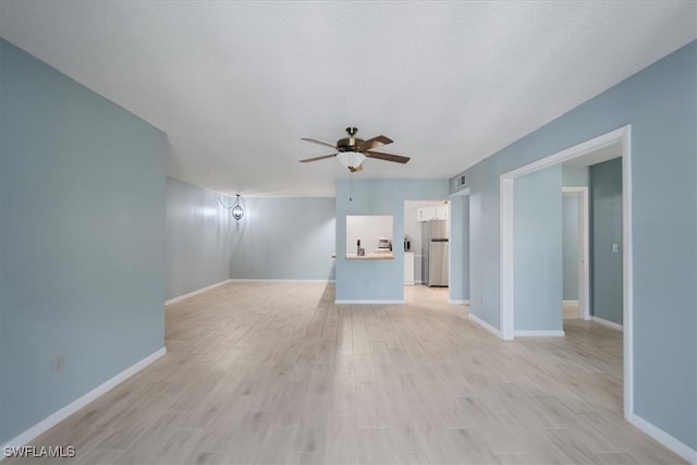 unfurnished living room featuring ceiling fan and light hardwood / wood-style flooring