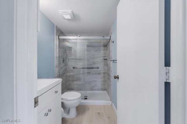 bathroom featuring toilet, vanity, wood-type flooring, and walk in shower