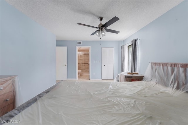 unfurnished bedroom with a closet, a textured ceiling, ceiling fan, and ensuite bathroom