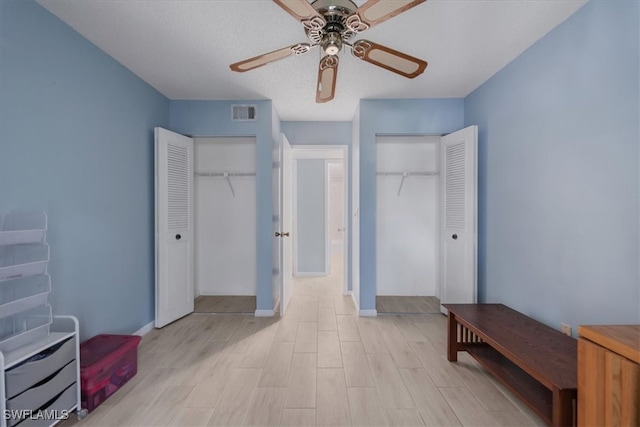 unfurnished bedroom featuring light wood-type flooring, a textured ceiling, and ceiling fan