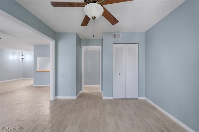 unfurnished bedroom featuring a closet, ceiling fan, a textured ceiling, and light hardwood / wood-style floors