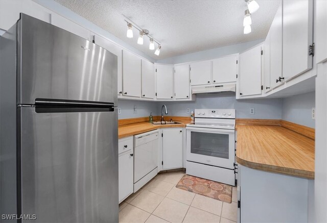 kitchen with white cabinets, a textured ceiling, sink, light tile patterned floors, and white appliances