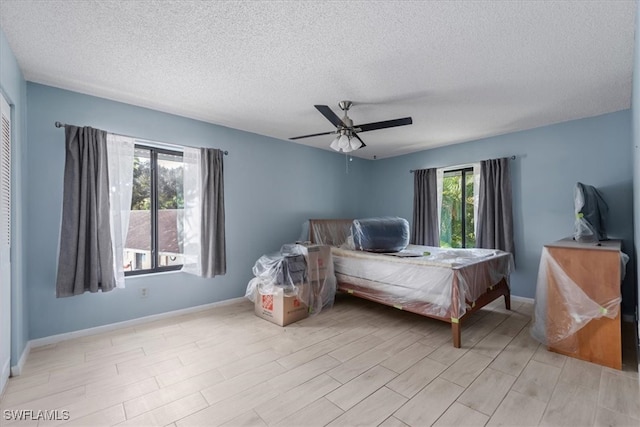 bedroom with a textured ceiling, ceiling fan, and light hardwood / wood-style flooring