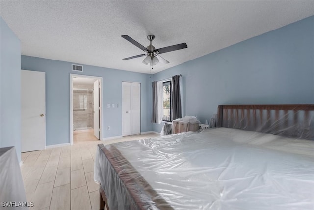 unfurnished bedroom featuring a closet, connected bathroom, a textured ceiling, ceiling fan, and light hardwood / wood-style flooring