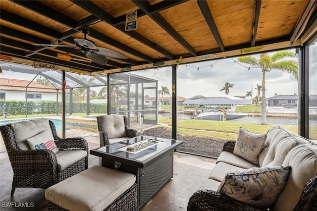 sunroom with ceiling fan, wood ceiling, and a water view