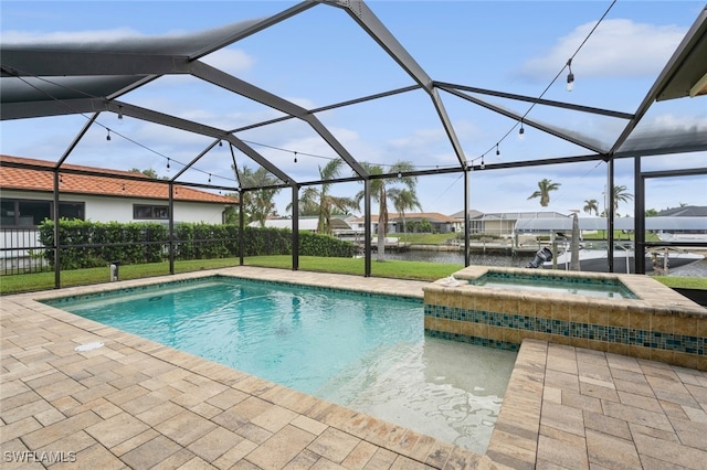 view of pool featuring a patio, a water view, a lanai, and an in ground hot tub