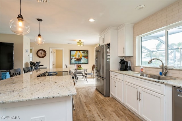 kitchen with white cabinets, sink, light hardwood / wood-style flooring, and appliances with stainless steel finishes