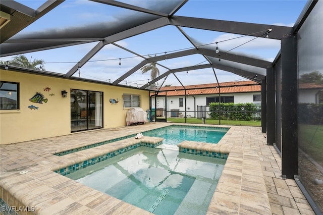 view of pool with a patio, a lanai, and an in ground hot tub