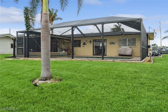 rear view of property featuring glass enclosure and a lawn