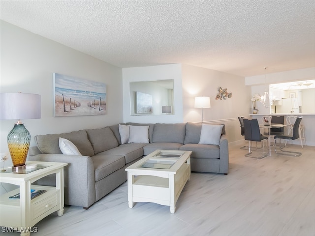 living room with a textured ceiling and light wood-type flooring