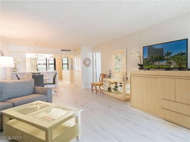 living room with light hardwood / wood-style flooring and a textured ceiling