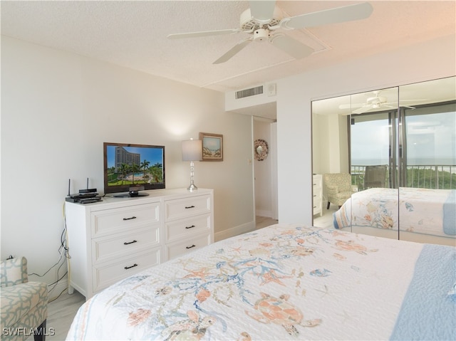 bedroom with a textured ceiling, access to outside, and ceiling fan