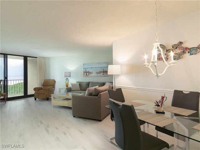 living room featuring expansive windows, an inviting chandelier, and light wood-type flooring