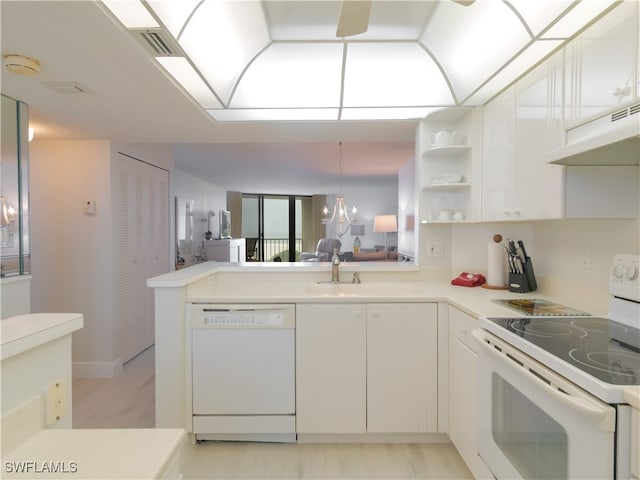 kitchen featuring kitchen peninsula, sink, white cabinetry, white appliances, and decorative light fixtures