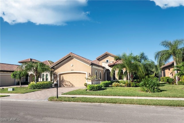 mediterranean / spanish-style house featuring a front yard and a garage