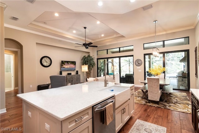 kitchen with hardwood / wood-style floors, a kitchen island with sink, white cabinets, stainless steel dishwasher, and ceiling fan