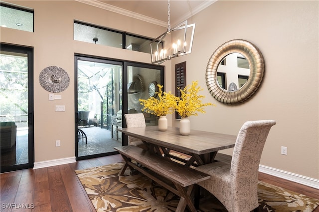 dining room featuring a notable chandelier, dark hardwood / wood-style flooring, crown molding, and a wealth of natural light