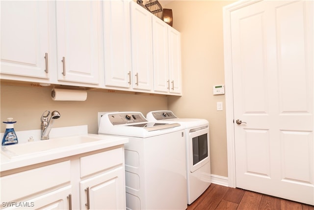 laundry area with washer and clothes dryer, dark hardwood / wood-style flooring, cabinets, and sink