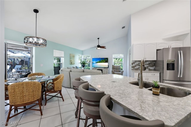 kitchen with ceiling fan, stainless steel fridge with ice dispenser, light tile patterned flooring, decorative light fixtures, and white cabinets