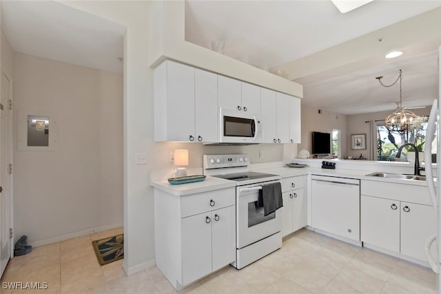 kitchen featuring white appliances, electric panel, sink, white cabinetry, and a chandelier