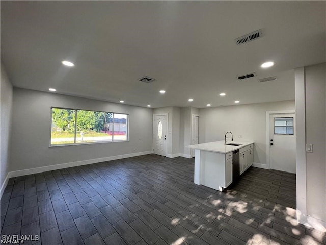 kitchen with dark wood-type flooring, white cabinetry, kitchen peninsula, and sink