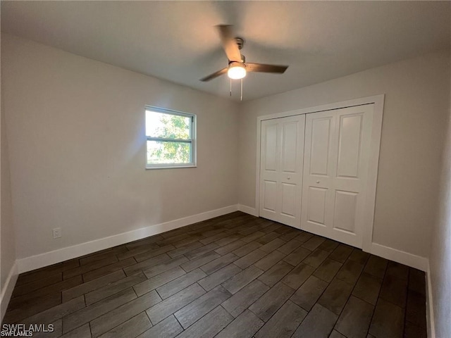 unfurnished bedroom with dark hardwood / wood-style flooring, ceiling fan, and a closet