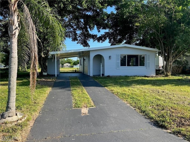 ranch-style home featuring a carport and a front yard