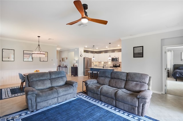 tiled living room featuring ceiling fan, ornamental molding, and sink