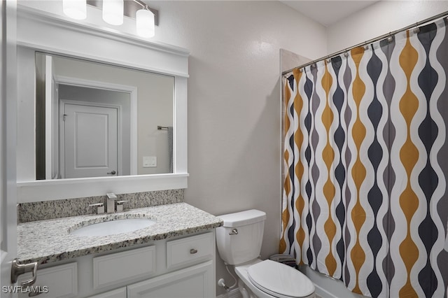 bathroom with curtained shower, vanity, and toilet