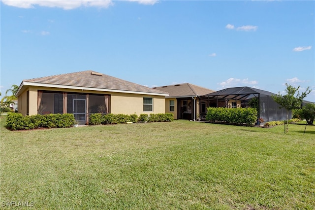 rear view of property with a lawn and a lanai