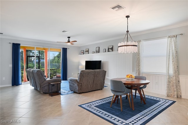 living room featuring ceiling fan with notable chandelier, crown molding, and light tile patterned flooring