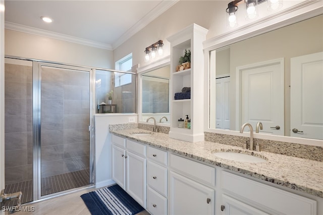 bathroom with vanity, a shower with shower door, and crown molding