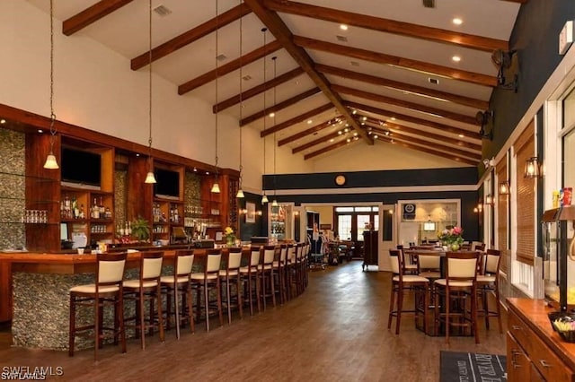 bar with beam ceiling, dark hardwood / wood-style flooring, high vaulted ceiling, and decorative light fixtures