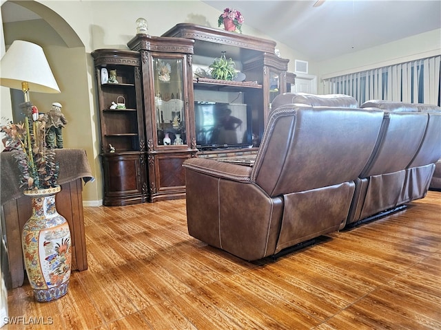 living room with hardwood / wood-style floors and vaulted ceiling