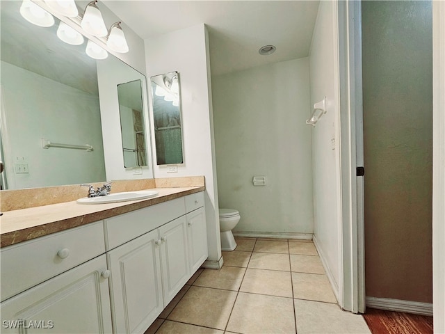 bathroom with tile patterned flooring, vanity, and toilet