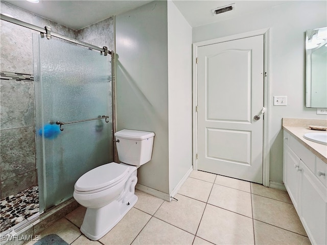 bathroom with toilet, tile patterned floors, vanity, and a shower with door