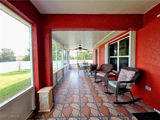 sunroom / solarium featuring a wealth of natural light and ceiling fan