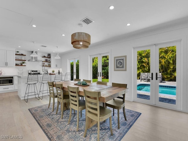 dining space featuring french doors and light hardwood / wood-style flooring